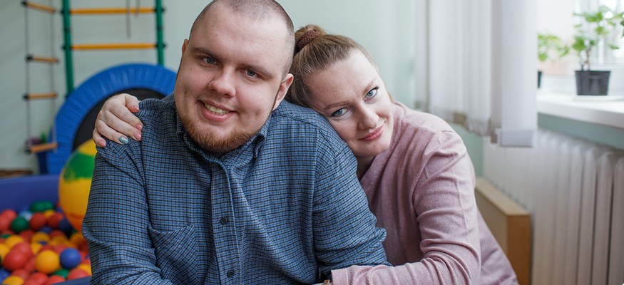 Young man and woman slightly smiling, woman leaning on man's shoulder